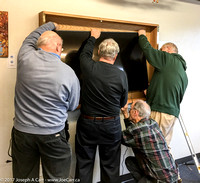 Reg, Dave, Terry and Les lift the TV up to the mount