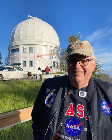 Chris Gainor with the Plaskett telescope dome behind