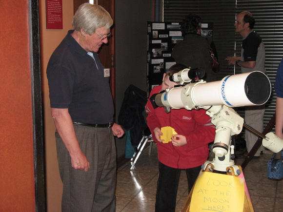 Bill Almond showing a boy the view of the Moon through a telescope