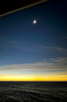 Fully-eclipsed Sun with Venus to the right and Jupiter to the left - over the ocean and dark skies